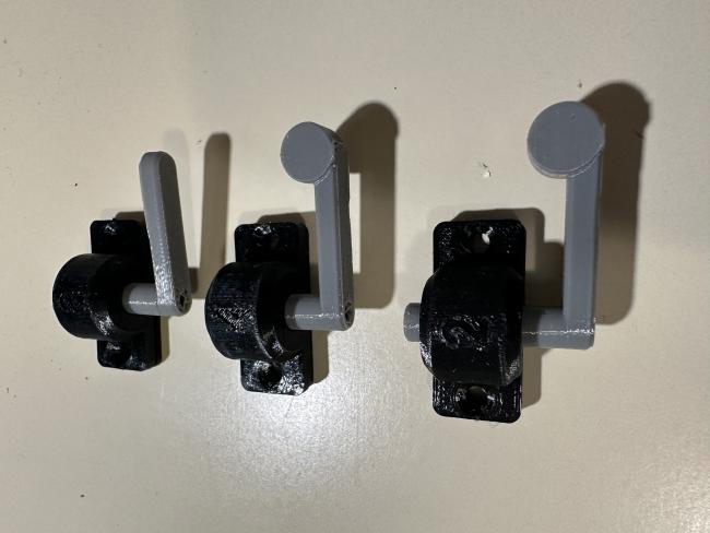 Three printed lever assemblies.